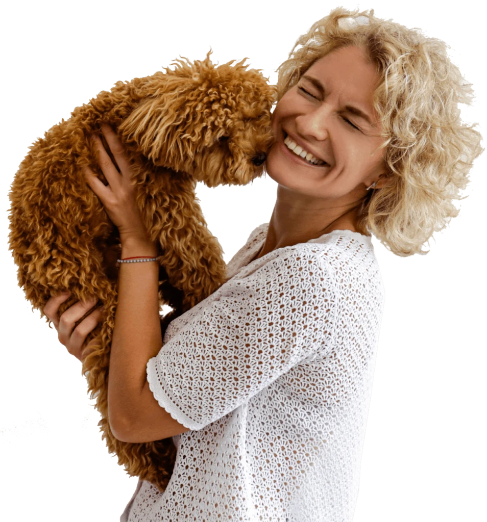 A smiling woman holding her happy dog